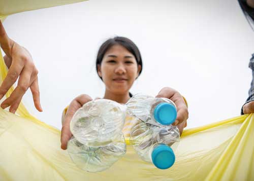 Woman throws plastic bottles away